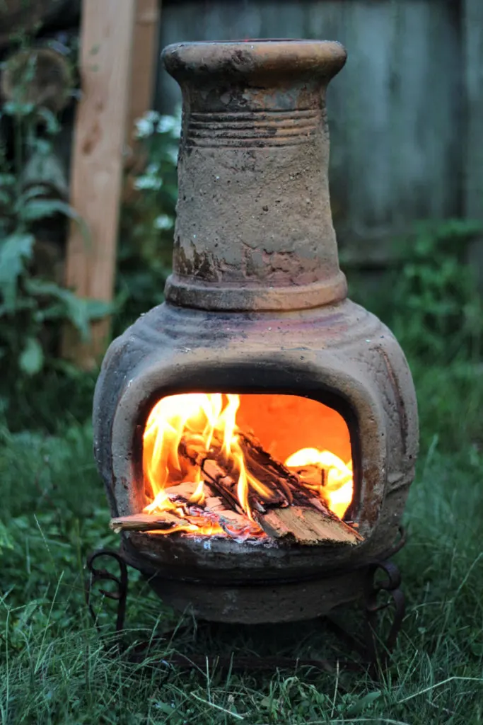 Clay chiminea with a fire going.