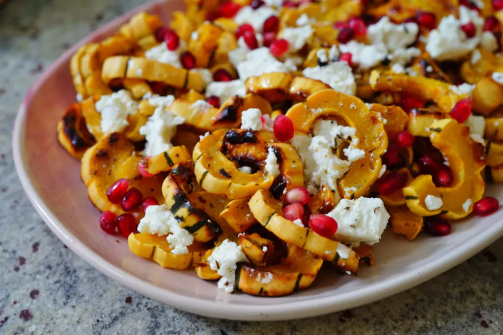 Roasted delicata squash rings tossed with goat cheese and pomegranate seeds