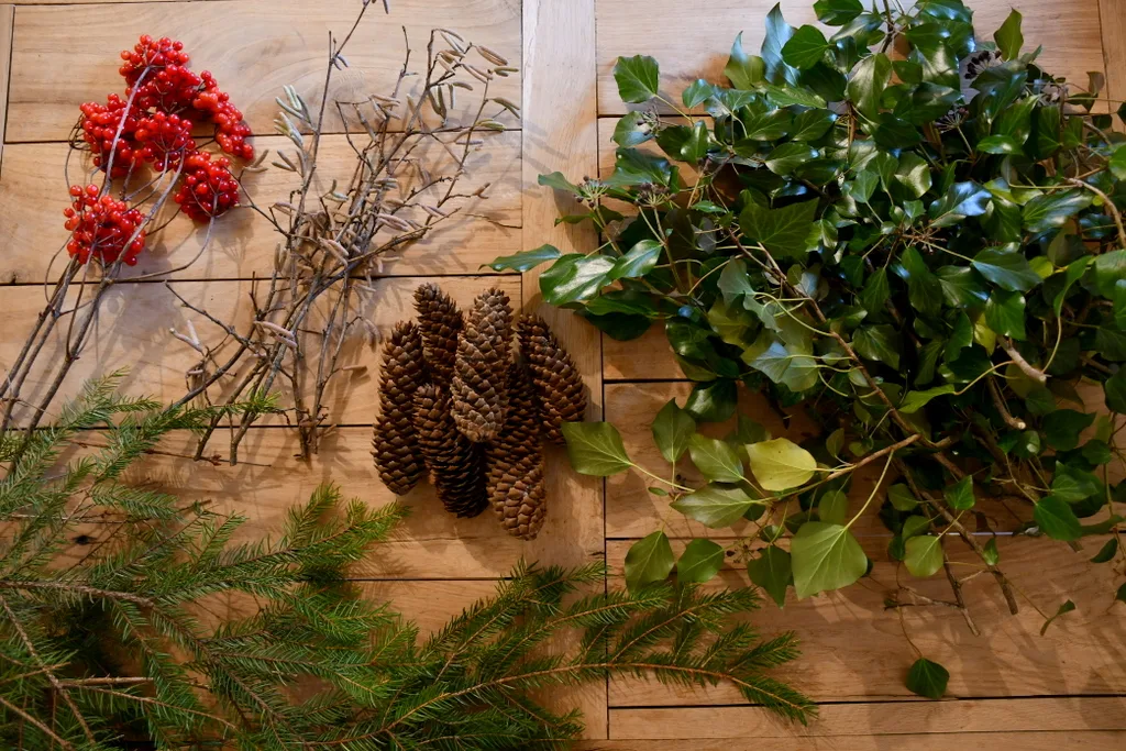 Piles of foraged greenery, berries and pinecones to make a wreath.