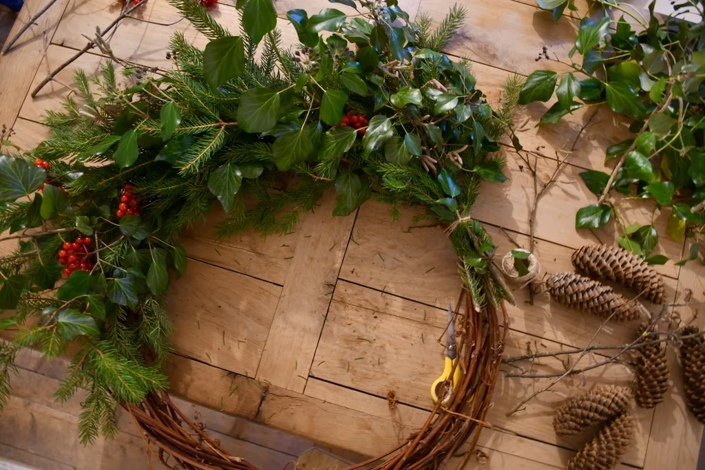 Nearly completed wreath, half covered with bundles of greenery