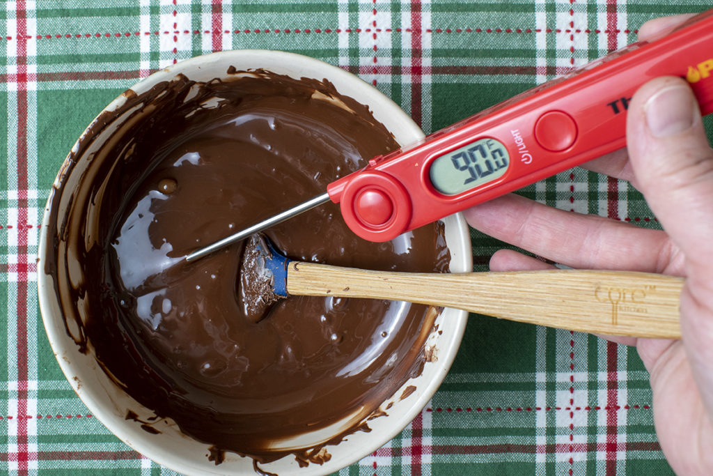 measuring the temperature of melted chocolate with digital thermometer
