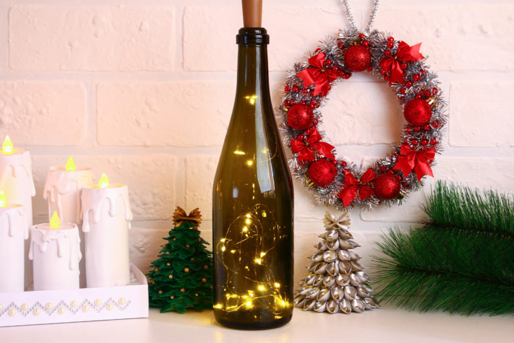 A wine bottle with a string of fairy lights in it to use as a last minute Christmas tree.