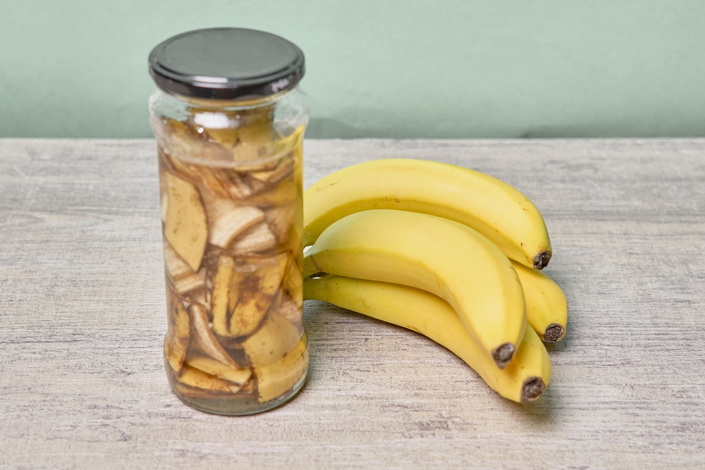Jar of banana fertilizer next to bananas