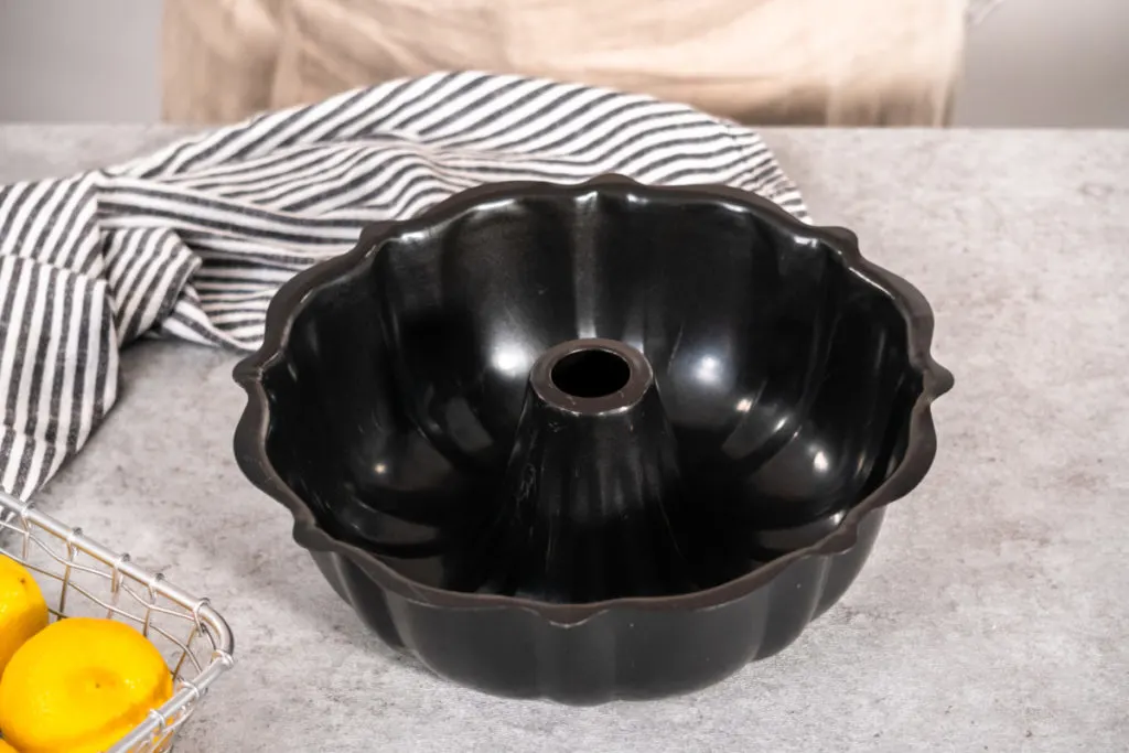 Empty black bundt pan on a counter.