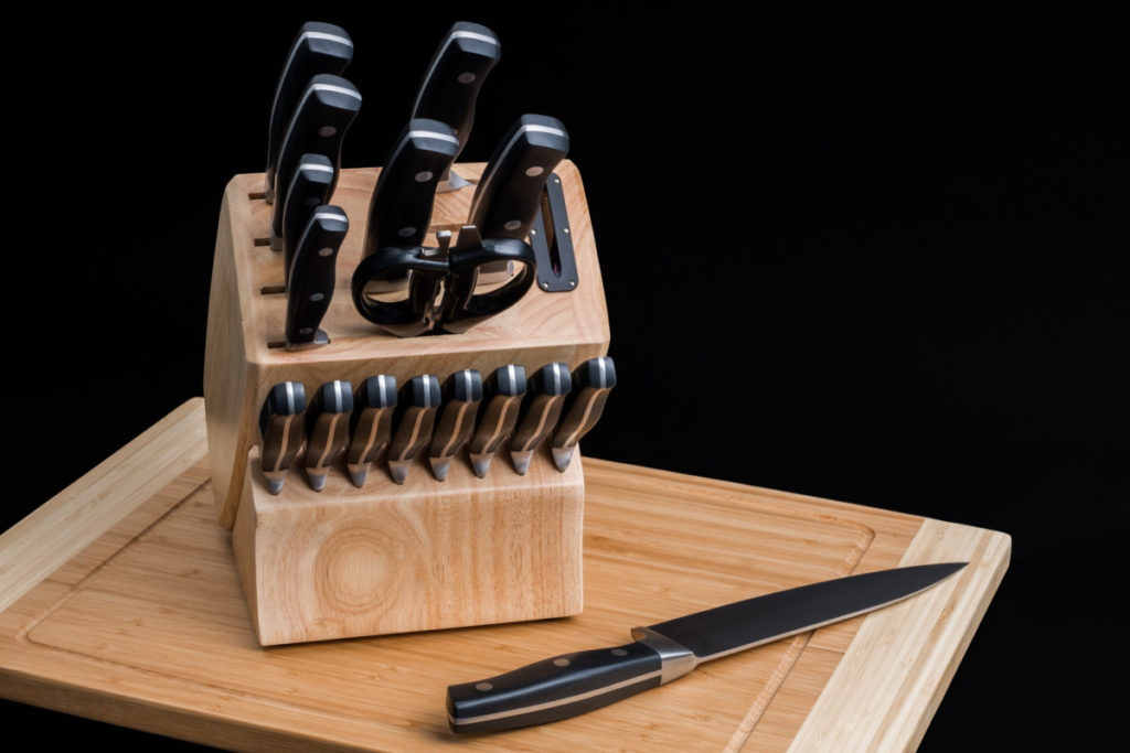 A fancy knife block set on a cutting board.