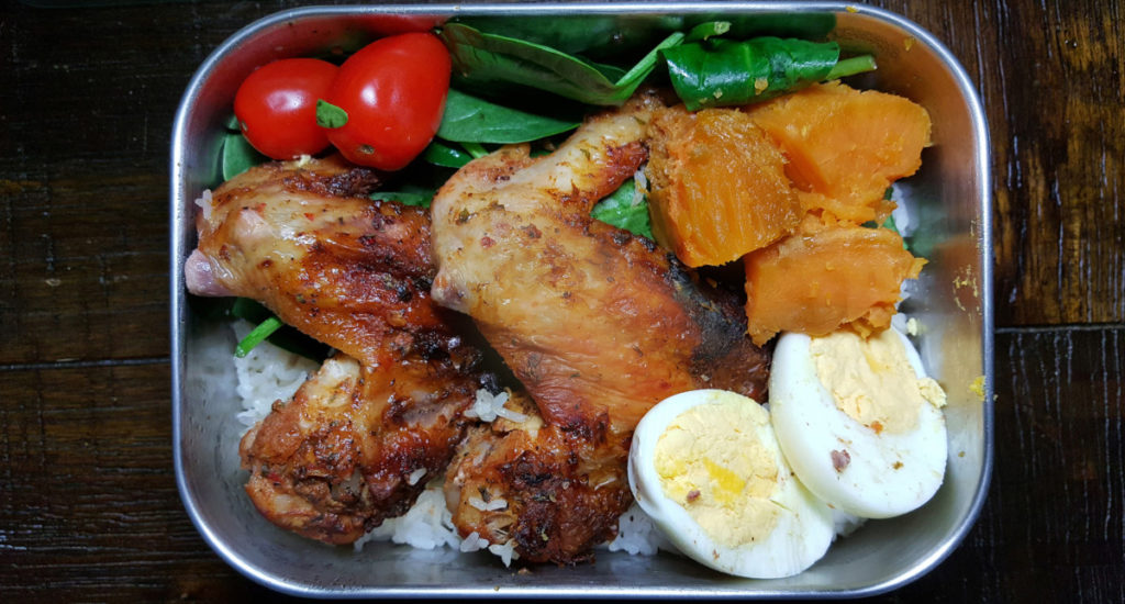Bento box with chicken, hard-boiled egg and salad