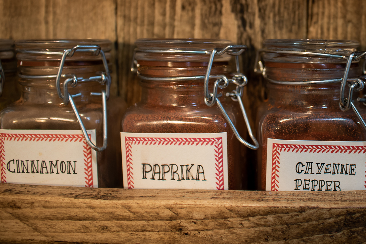 Jars of cinnamon, paprika and cayenne pepper in spice rack