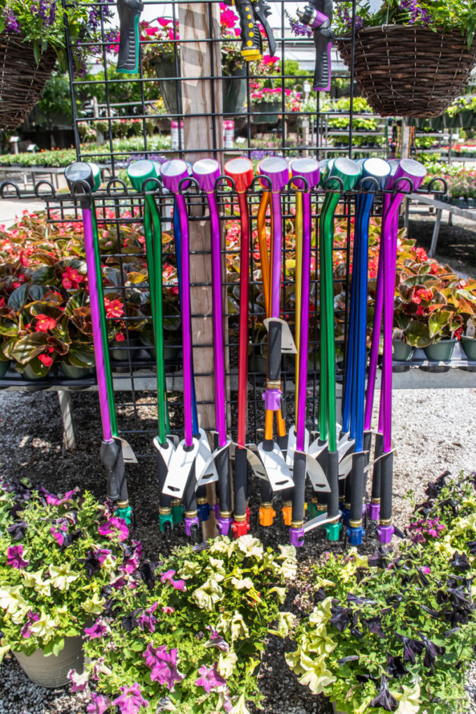 Collection of colorful watering wands for sale at garden center