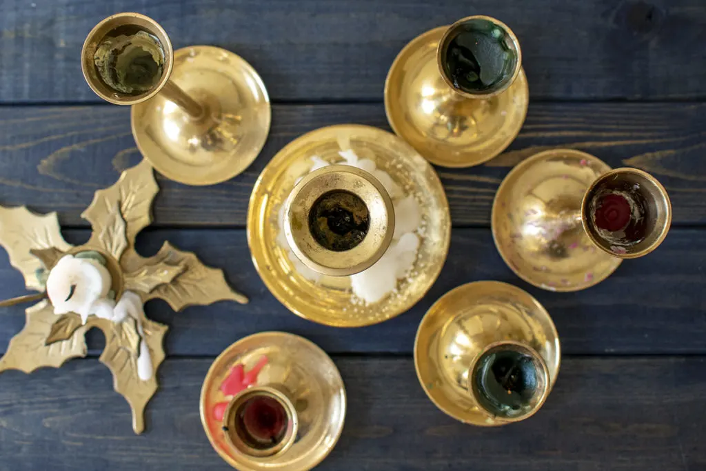 Overhead view of brass candlesticks covered in wax.