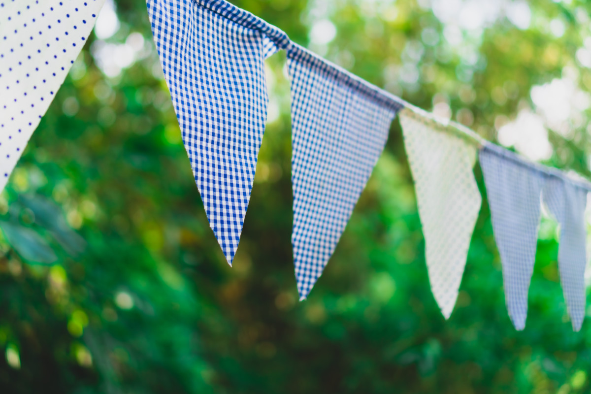 Homemade bunting flying in front of blurred greenery