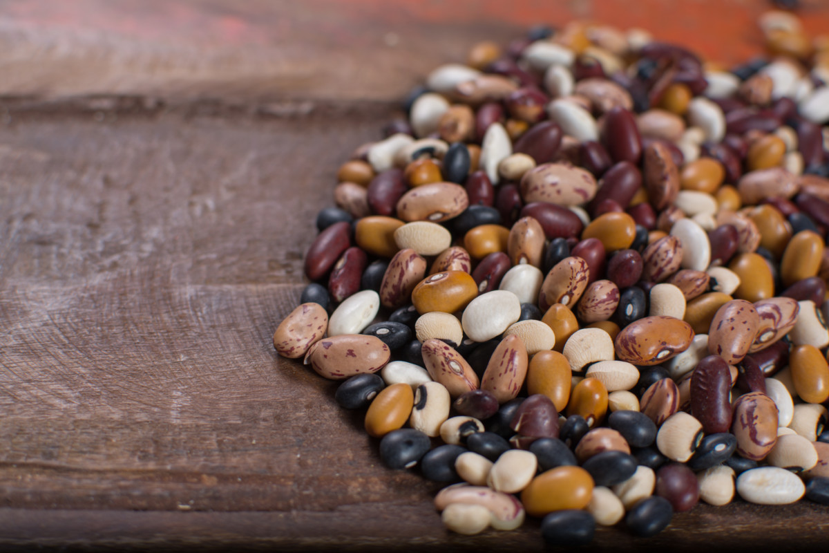 Assortment of dried beans on roughhewn table