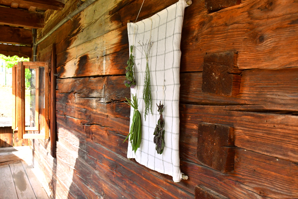 Herb drying screen against a log cabin