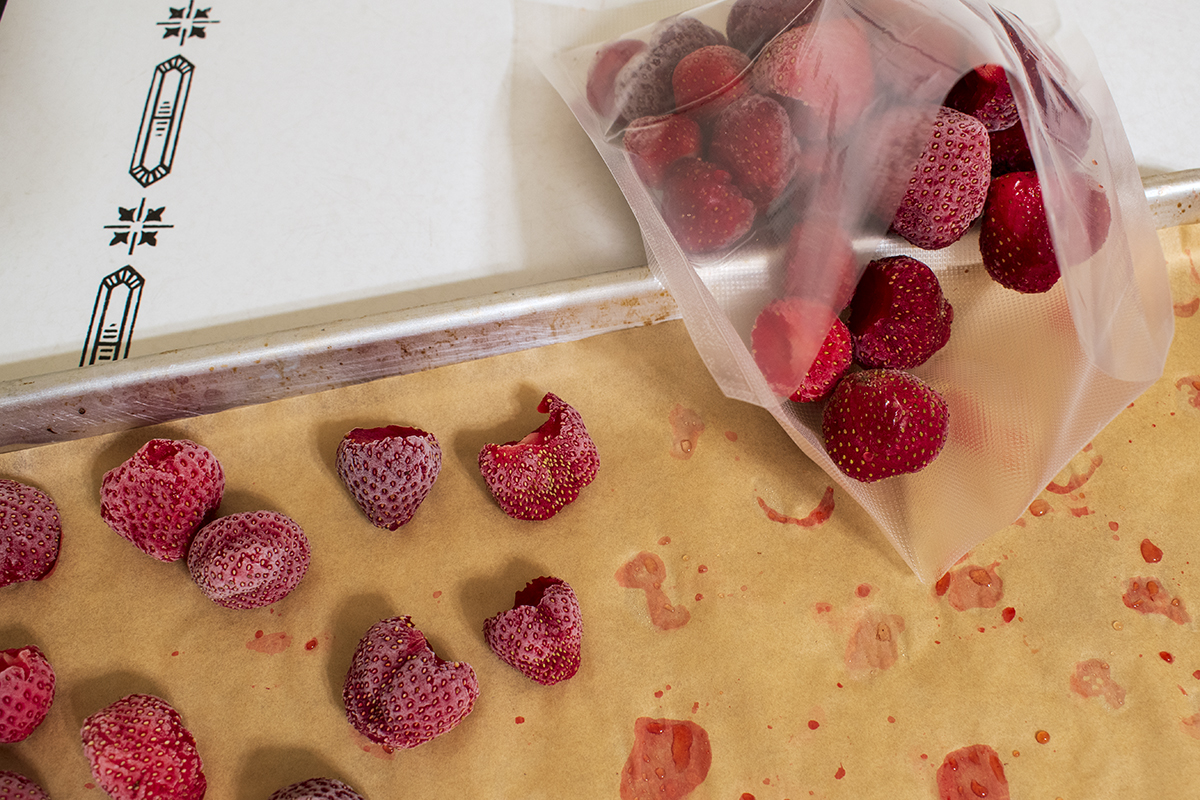 Vacuum sealer bag with frozen, whole strawberries in it