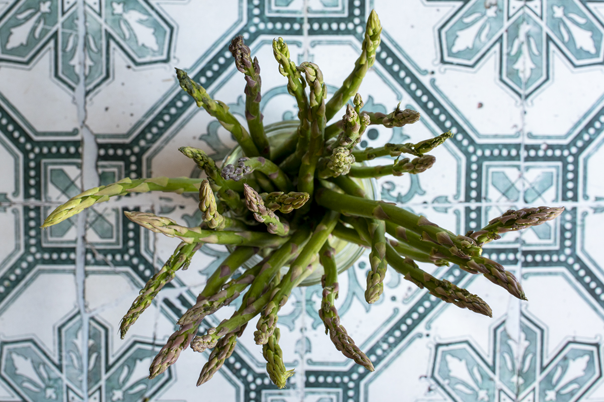 Overhead view of asparagus stems in a jar. 