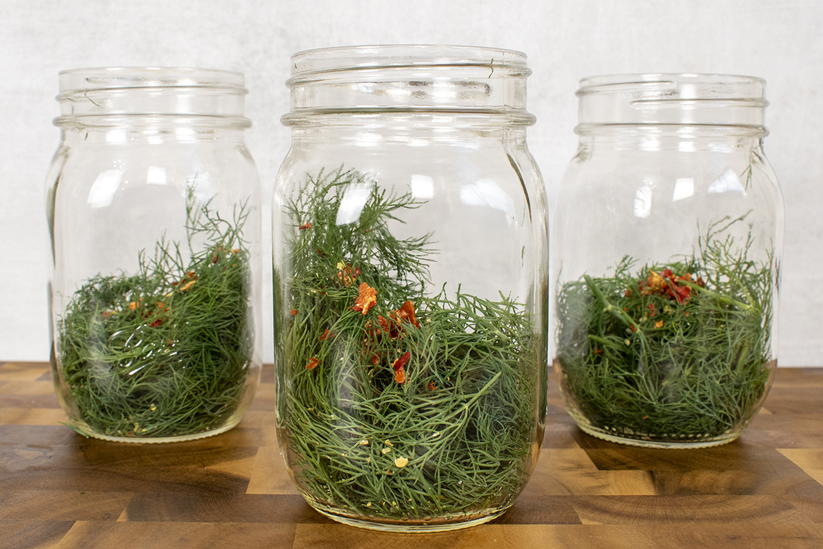 Mason jars with fresh dill and red pepper flakes