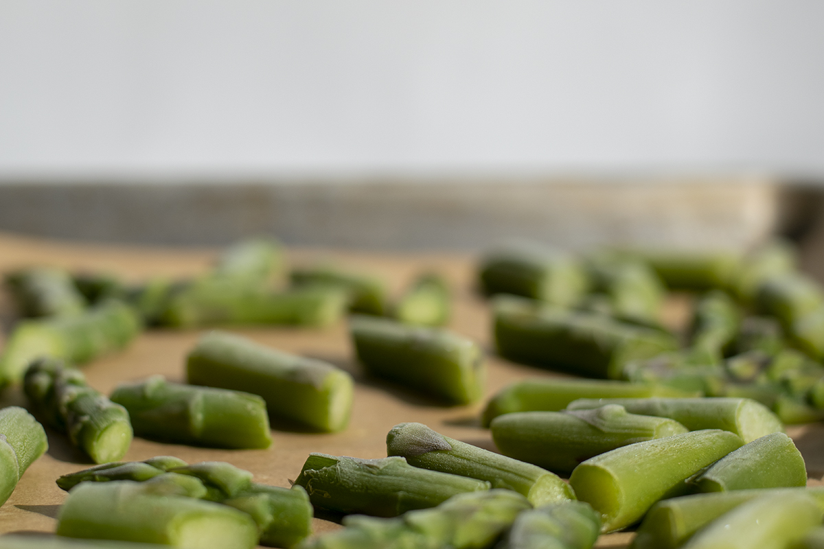 frozen asparagus chunks on a baking sheet
