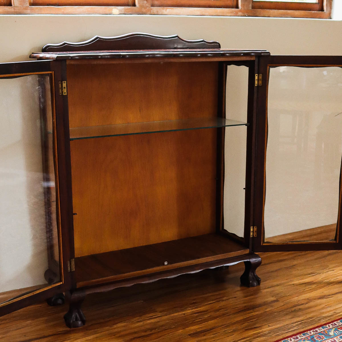 Old empty curio cabinet with glass doors and sides.