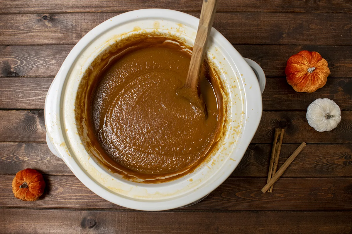 Overhead view of a slow-cooker with pumpkin butter cooking. 