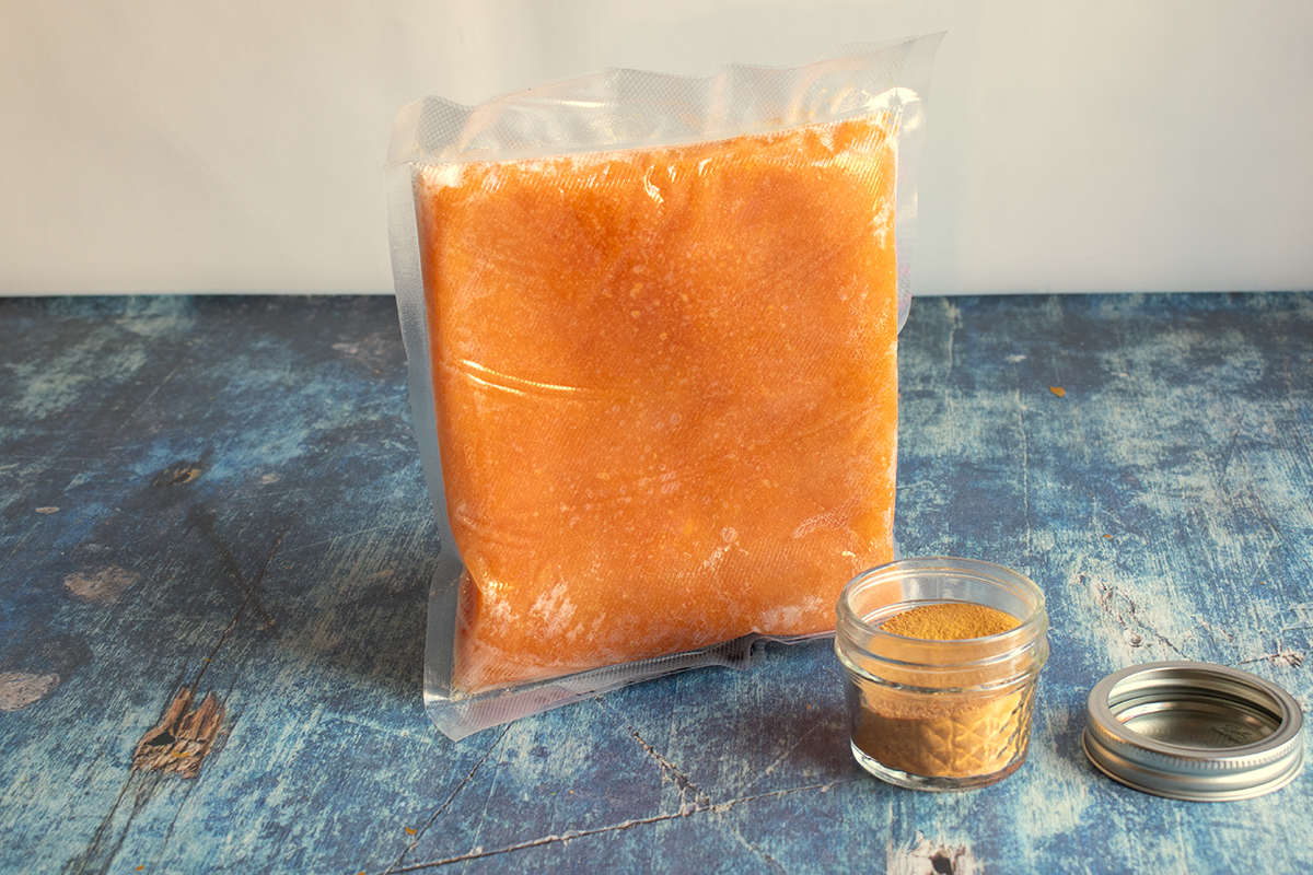 Bag of frozen pumpkin puree next to pumpkin powder in a jar.