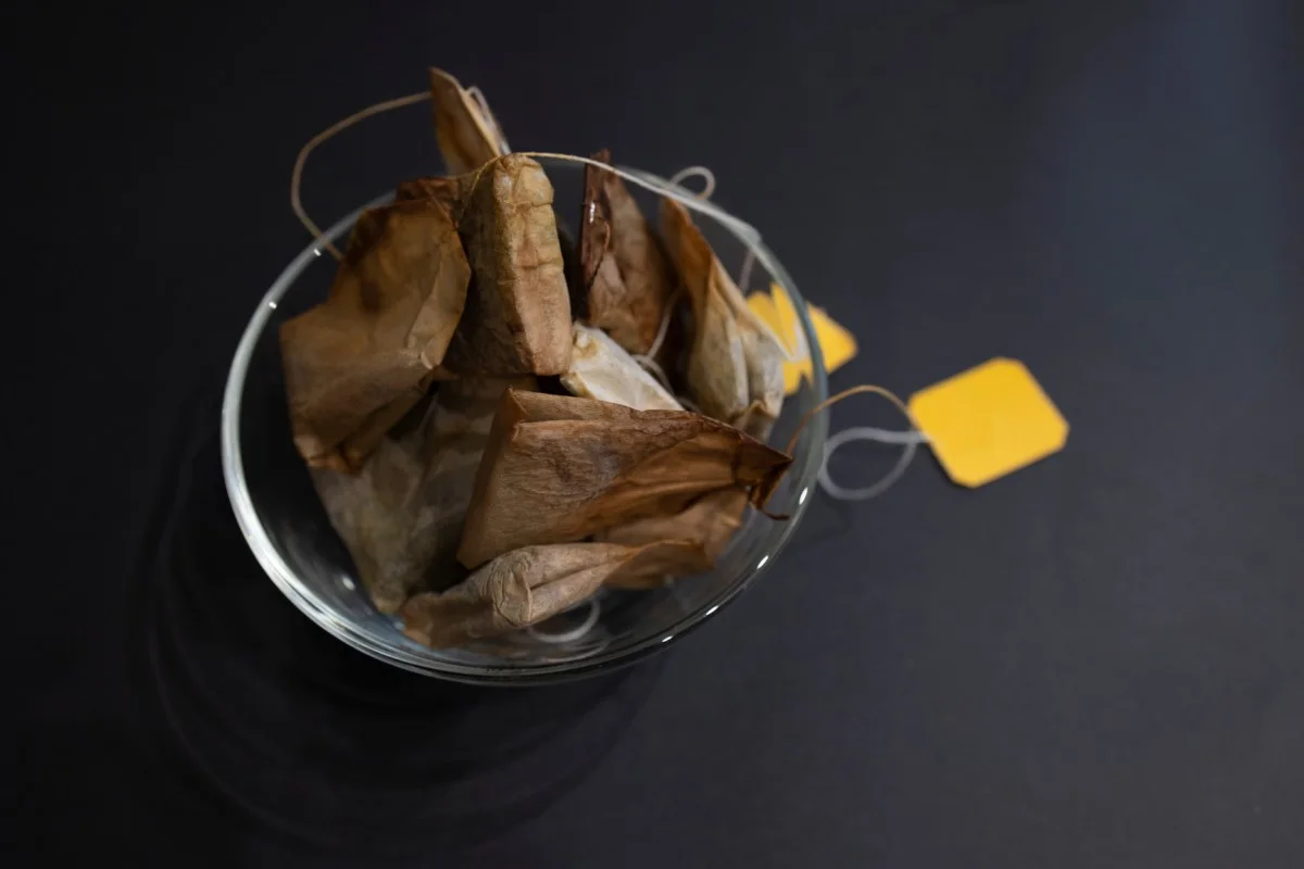 Used tea bags in a clear glass bowl. 