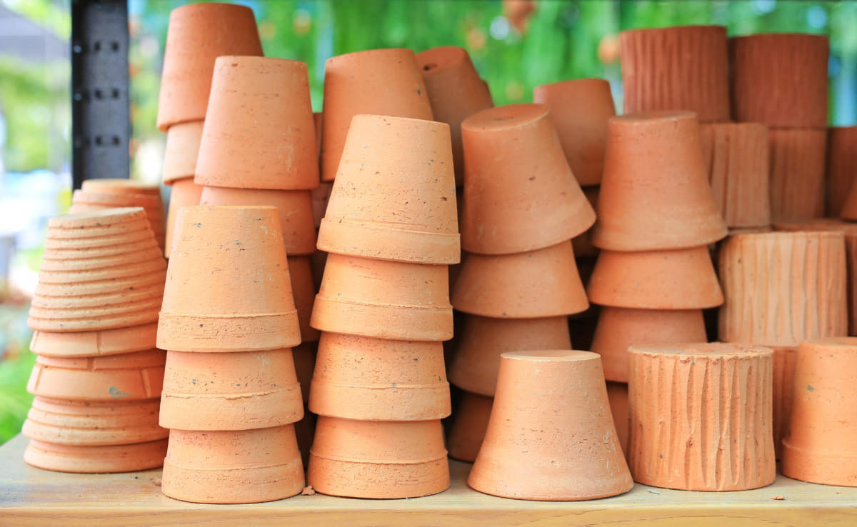 Pilhas de novos vasos de terracota laranja.