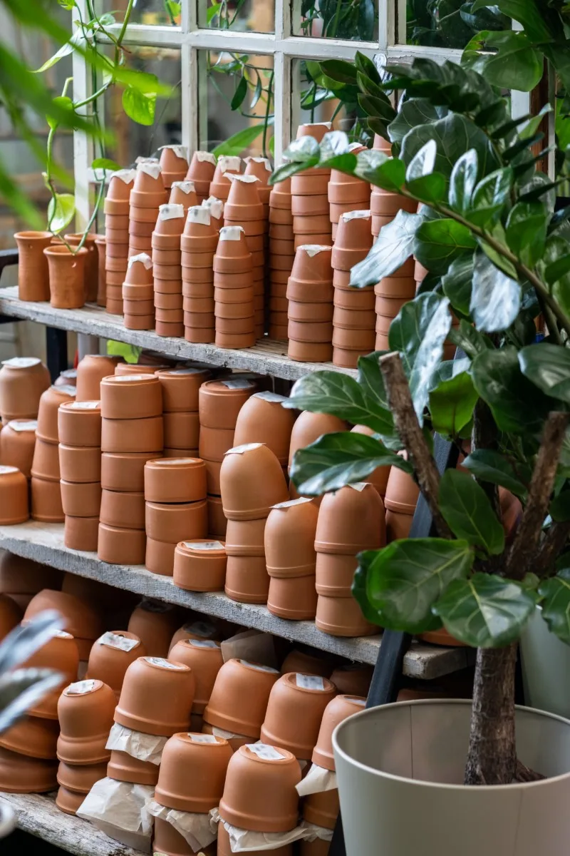 Stacks of terracotta pots and planters for sale in a garden center.
