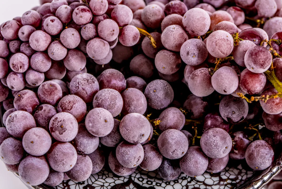 Frozen red grapes on a plate.