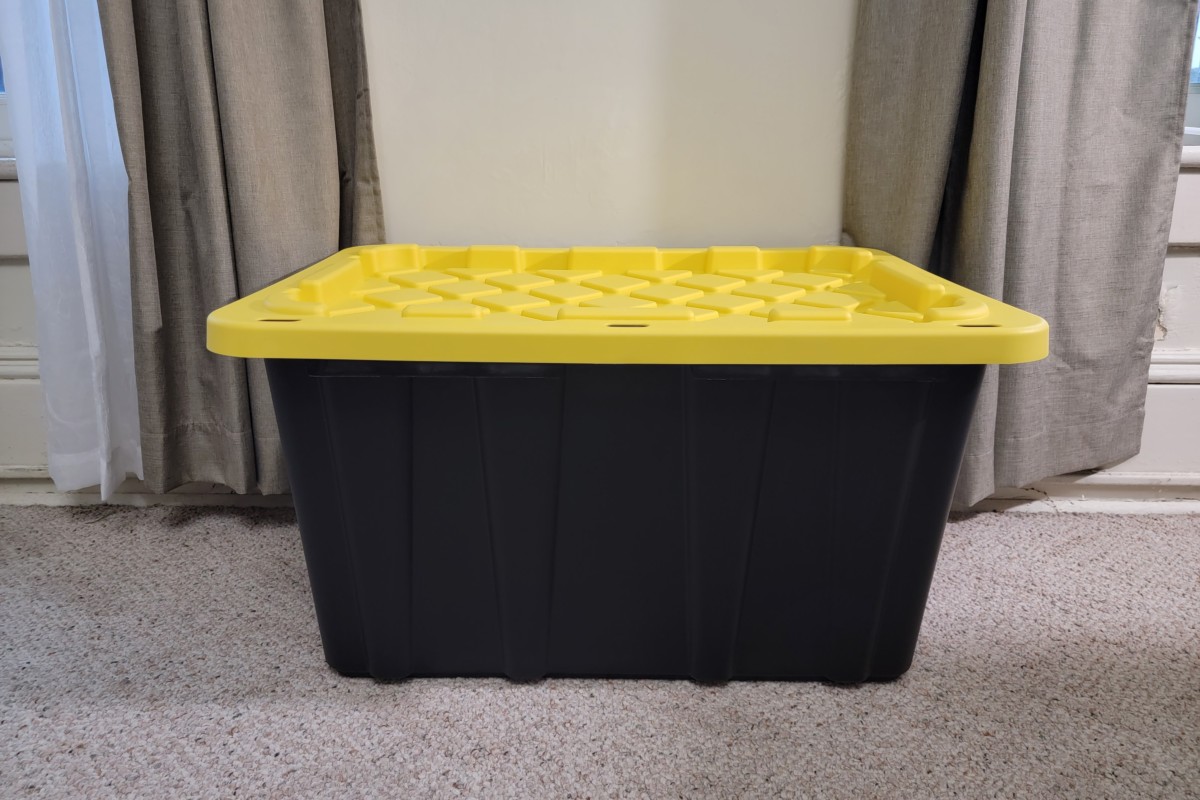Large black storage bin with a yellow lid. 
