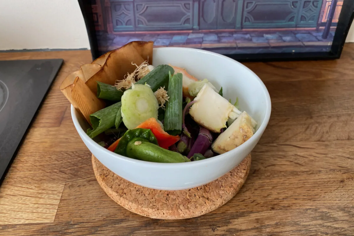 Bowl filled with kitchen scraps in a table. 