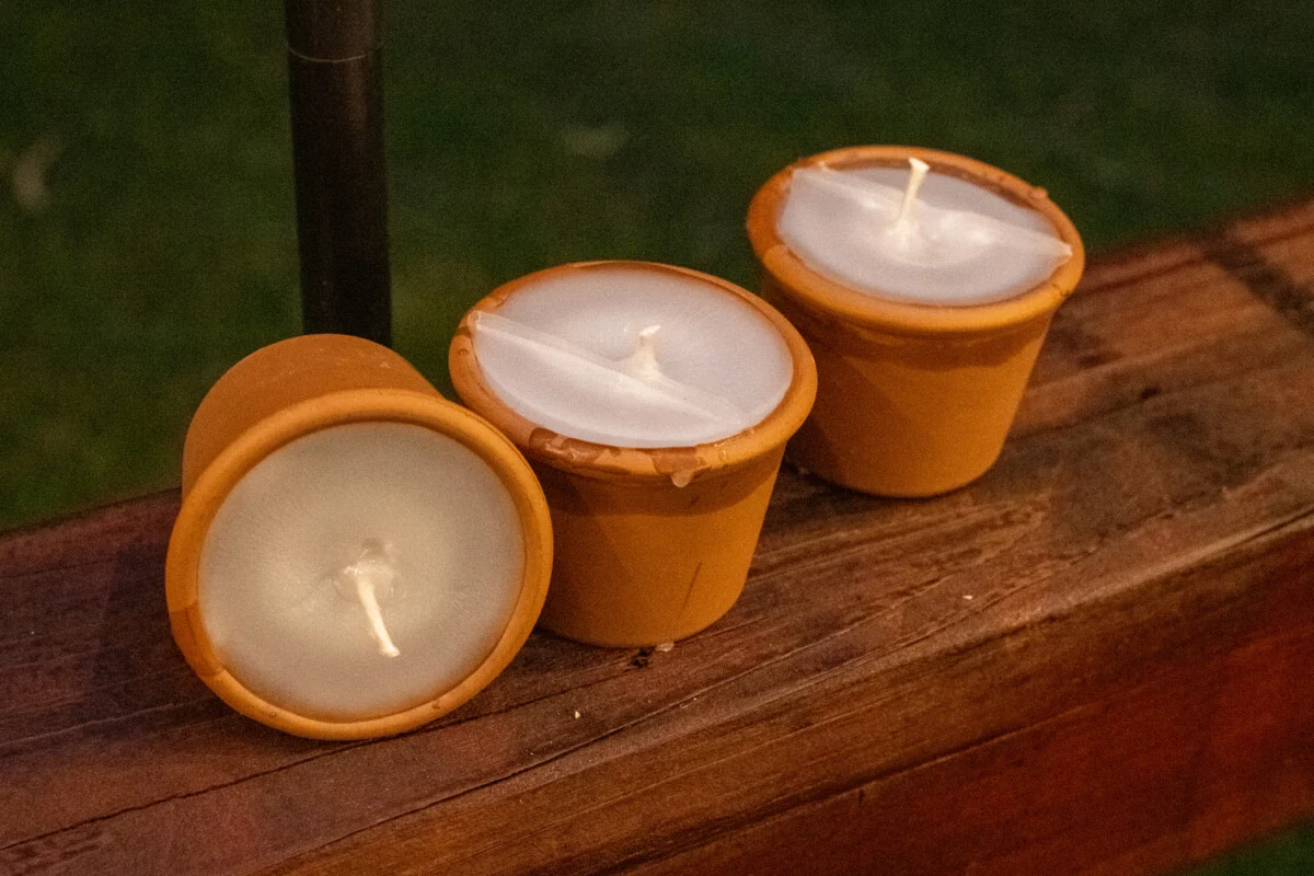 Three finished bug-repelling candles made with terracotta pots.