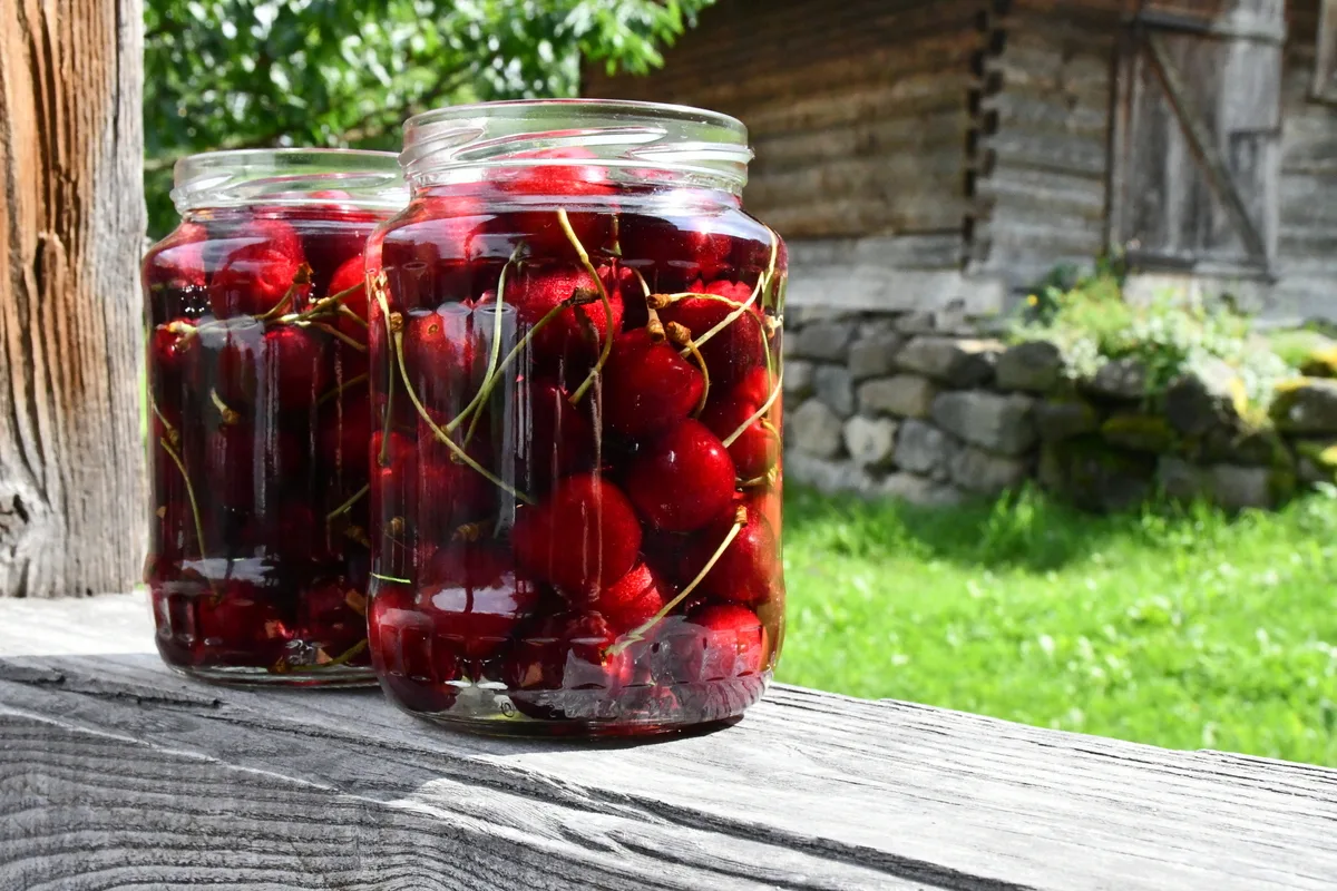 Brandied cherries in jars on a porch in the sun
