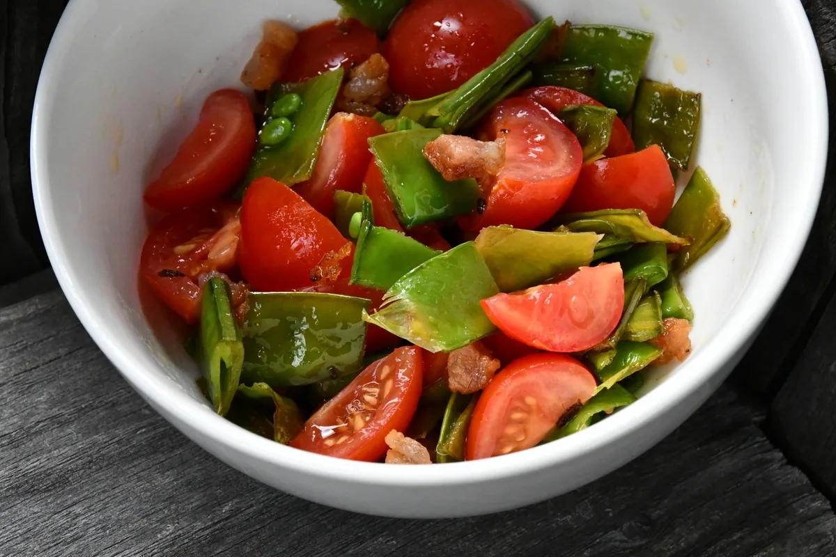 Salad made with tomatoes, peas and pea leaves.