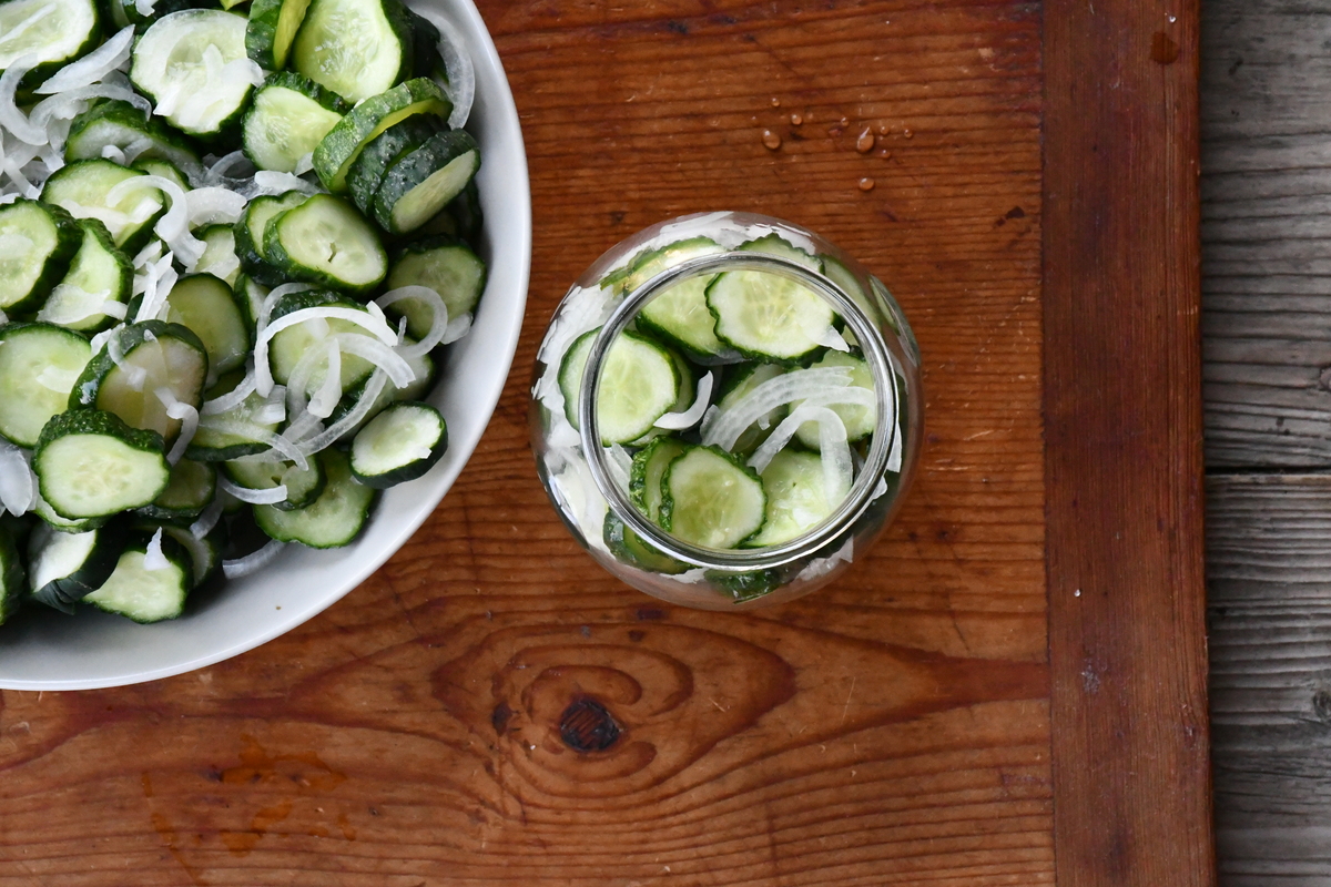 Slices cucumbers with onions. in a bowl and in a jar.