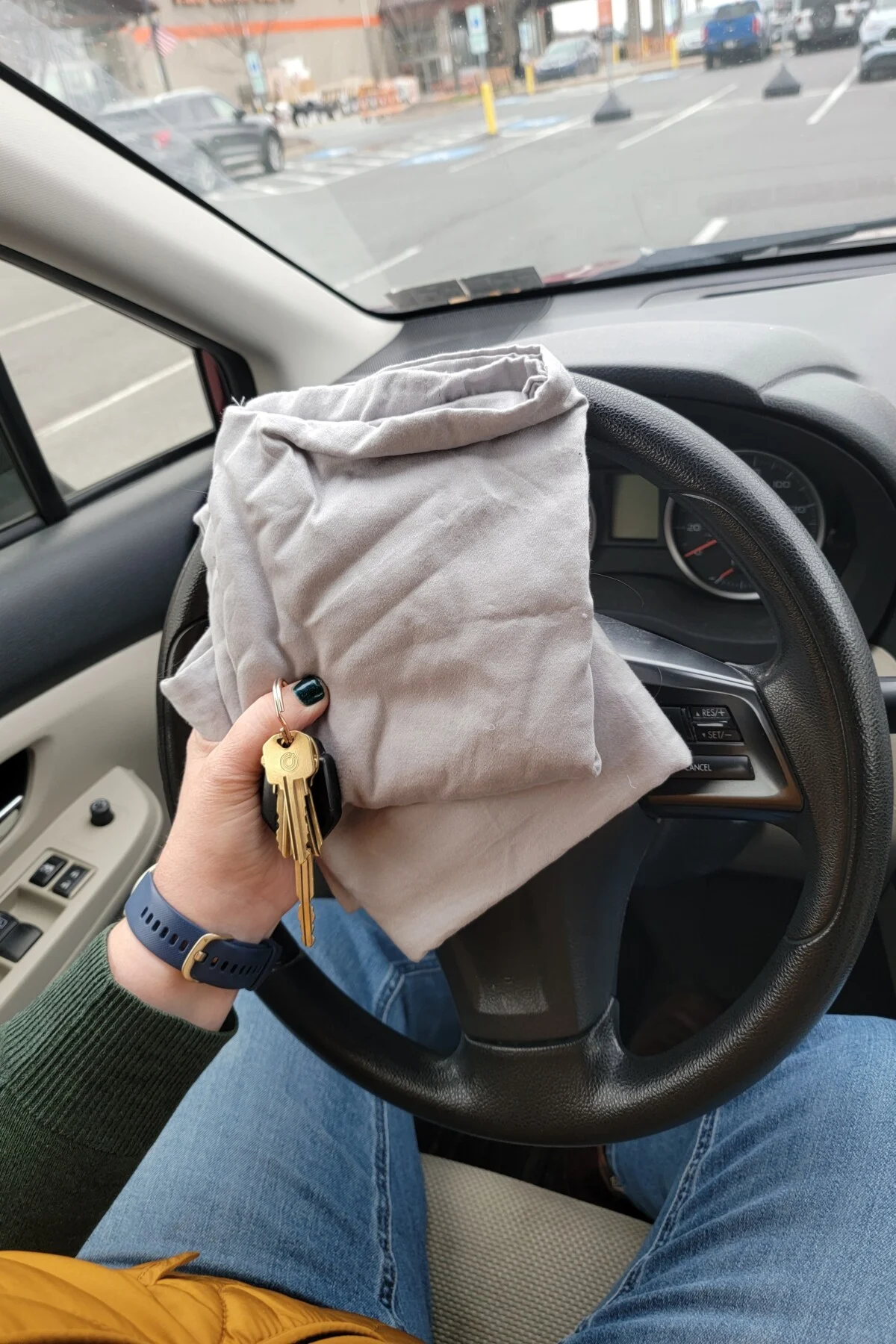 Woman's hand holding car keys and pillowcases