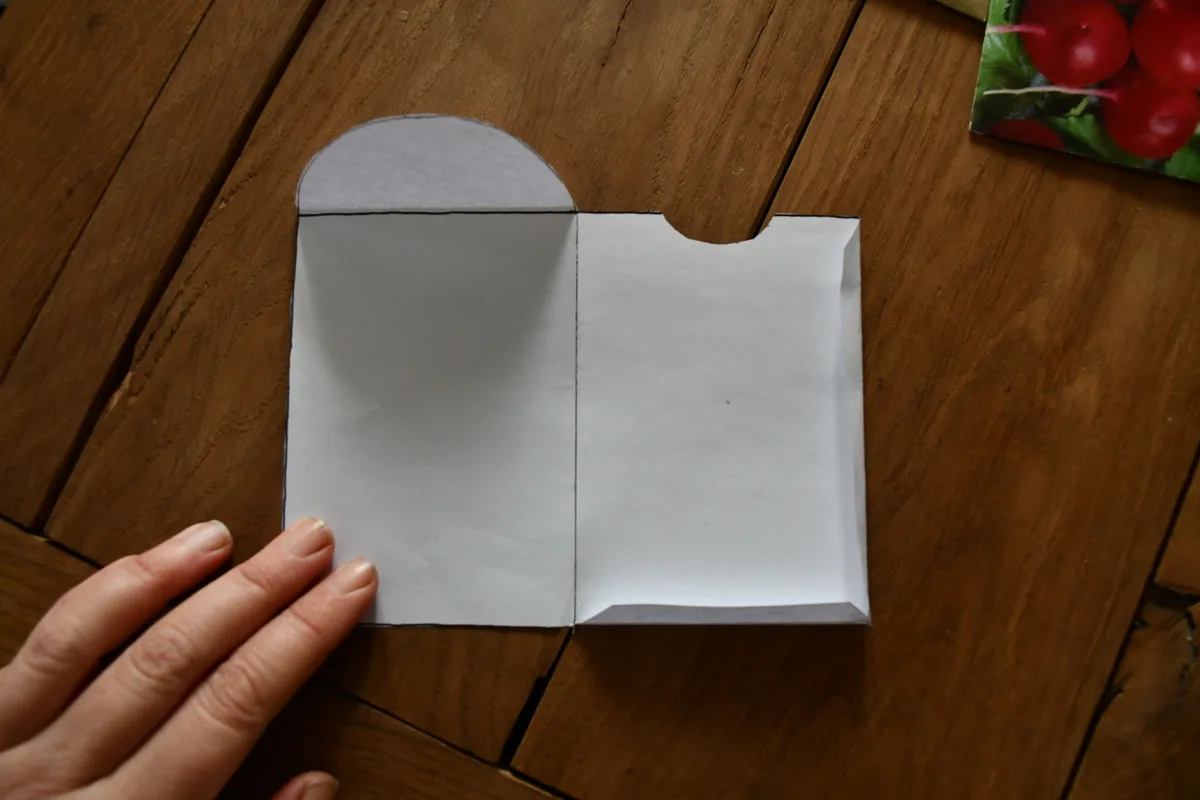 Seed packet template with someone's fingers at the edge