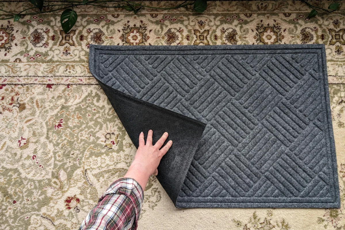 Waterproof doormat, hand showing underside of mat.