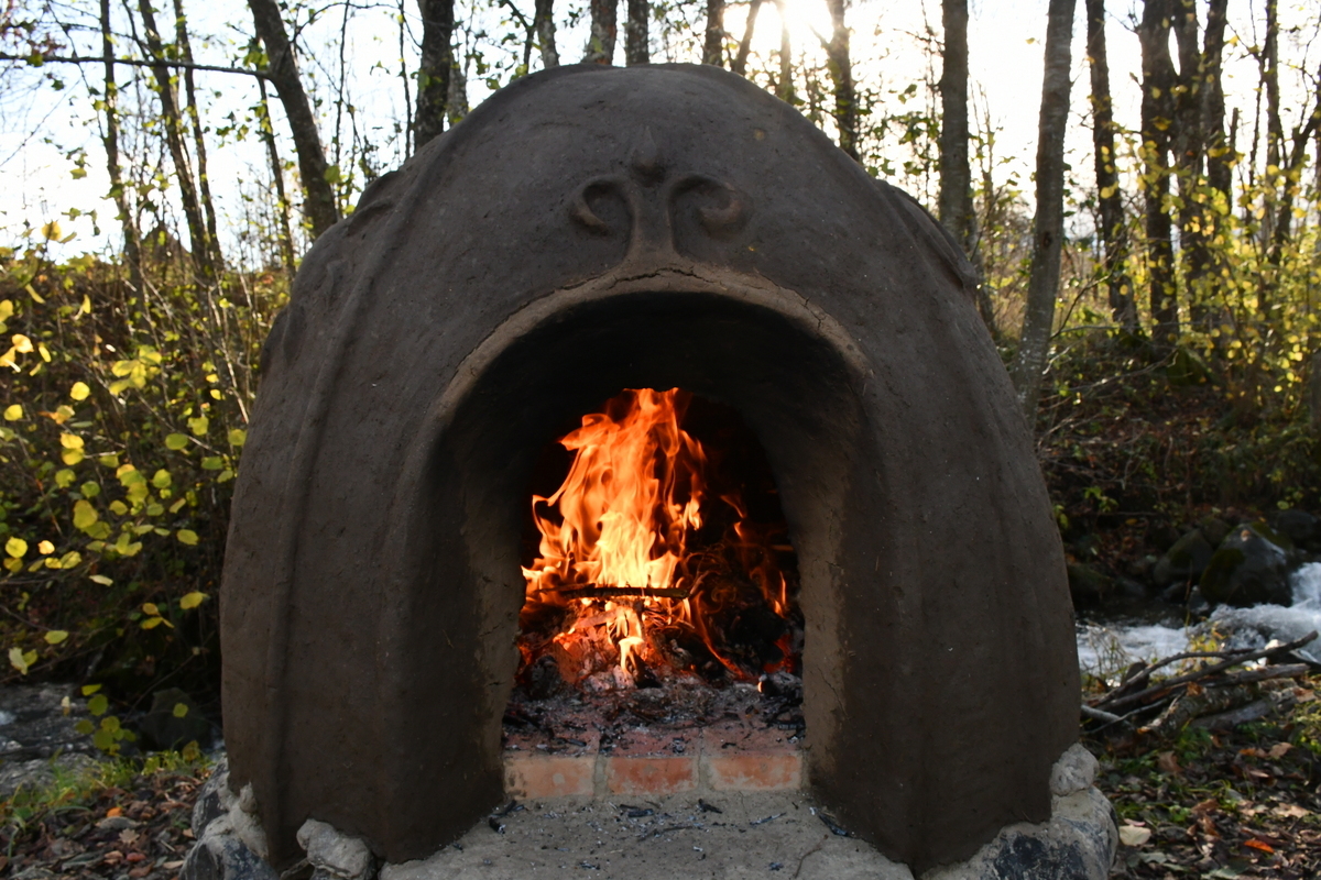 Cob oven with fire burning inside it