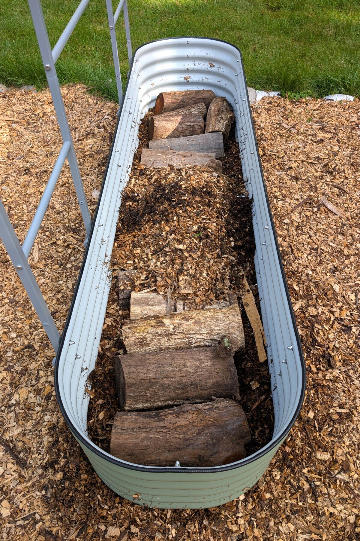 Raised bed filled with logs and wood chips