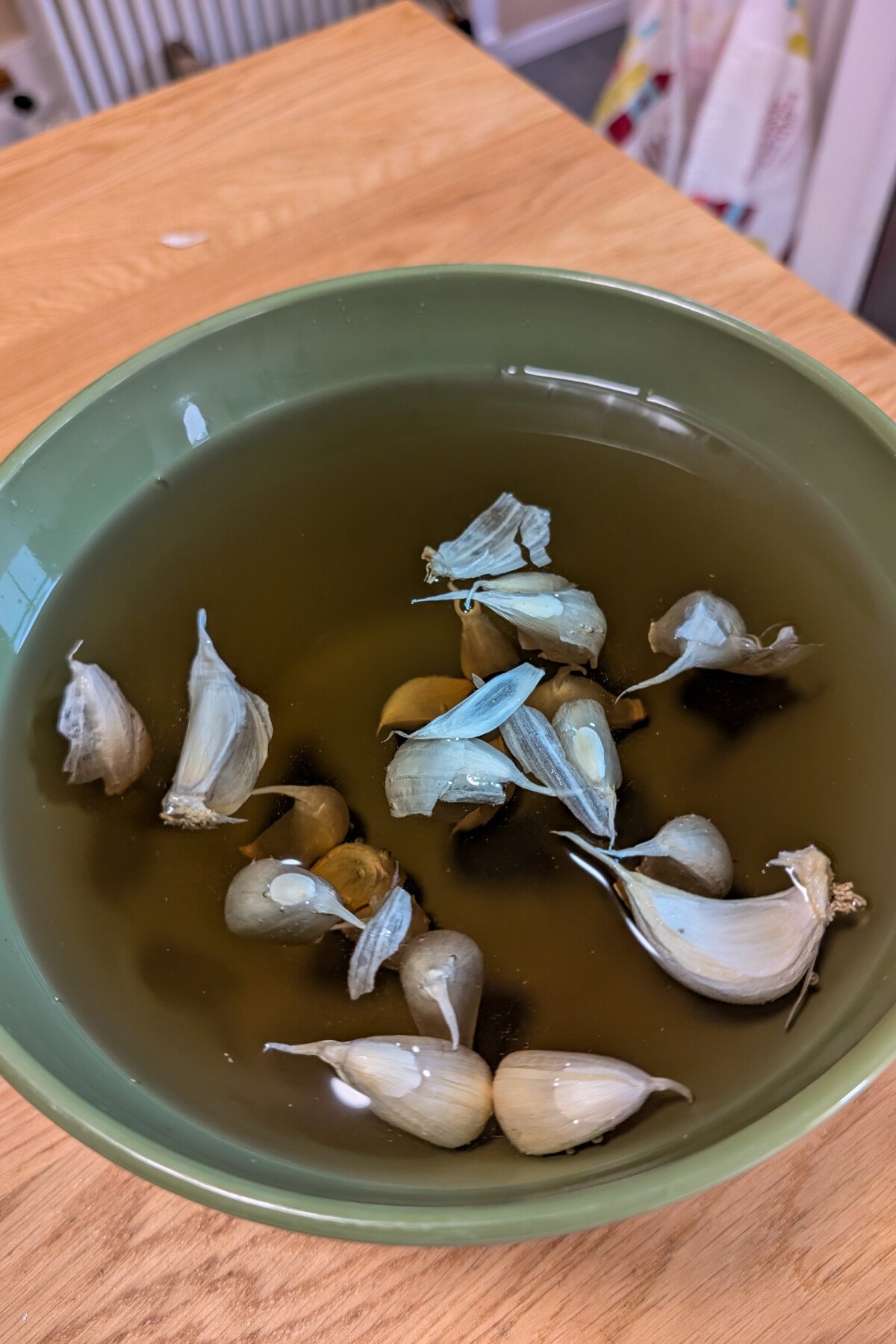Bowl of garlic cloves soaking in a fertilizing solution.
