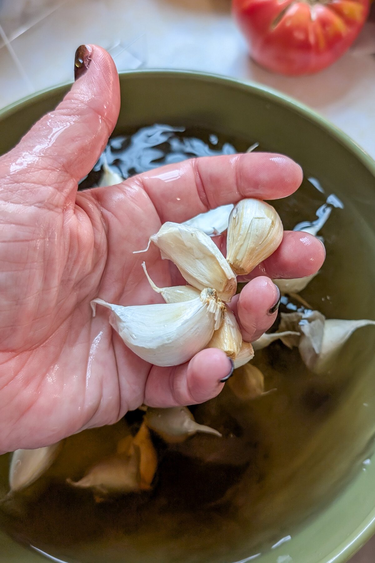Woman's hand holding wet garlic cloves