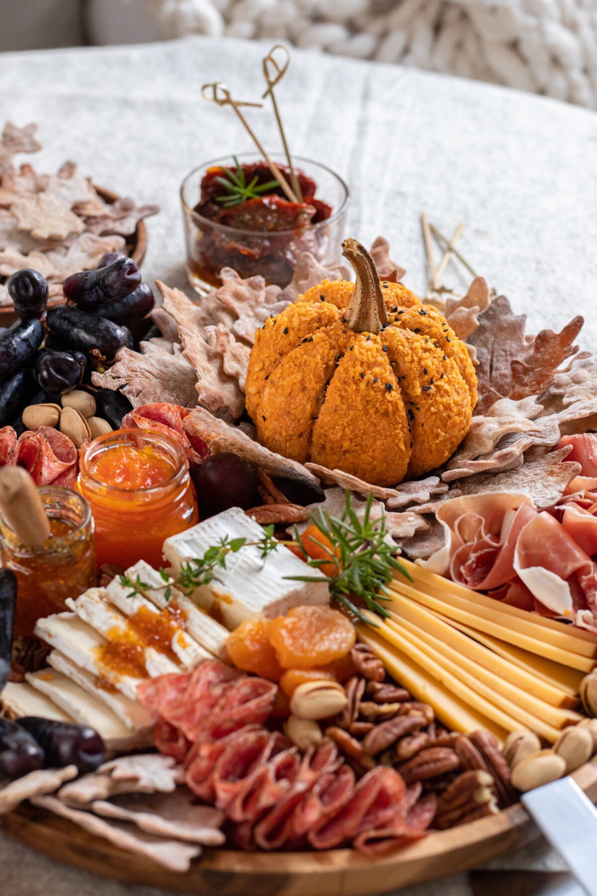 Pumpkin shaped cheese ball on a charcuterie board