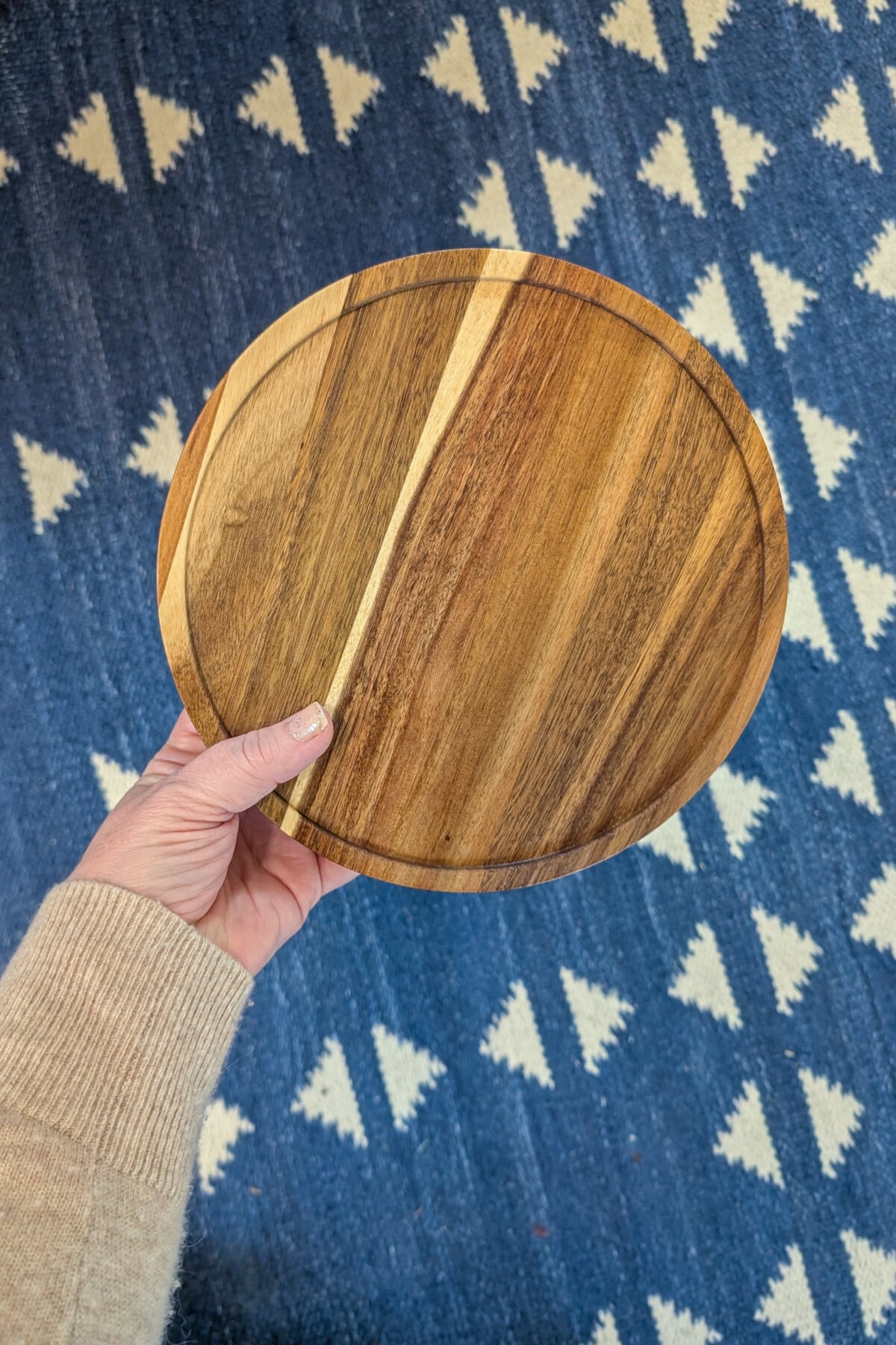 Woman's hand holding a wood lazy-susan.