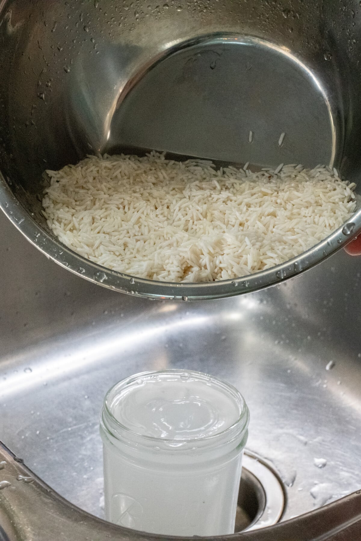 Straining rice water into jar