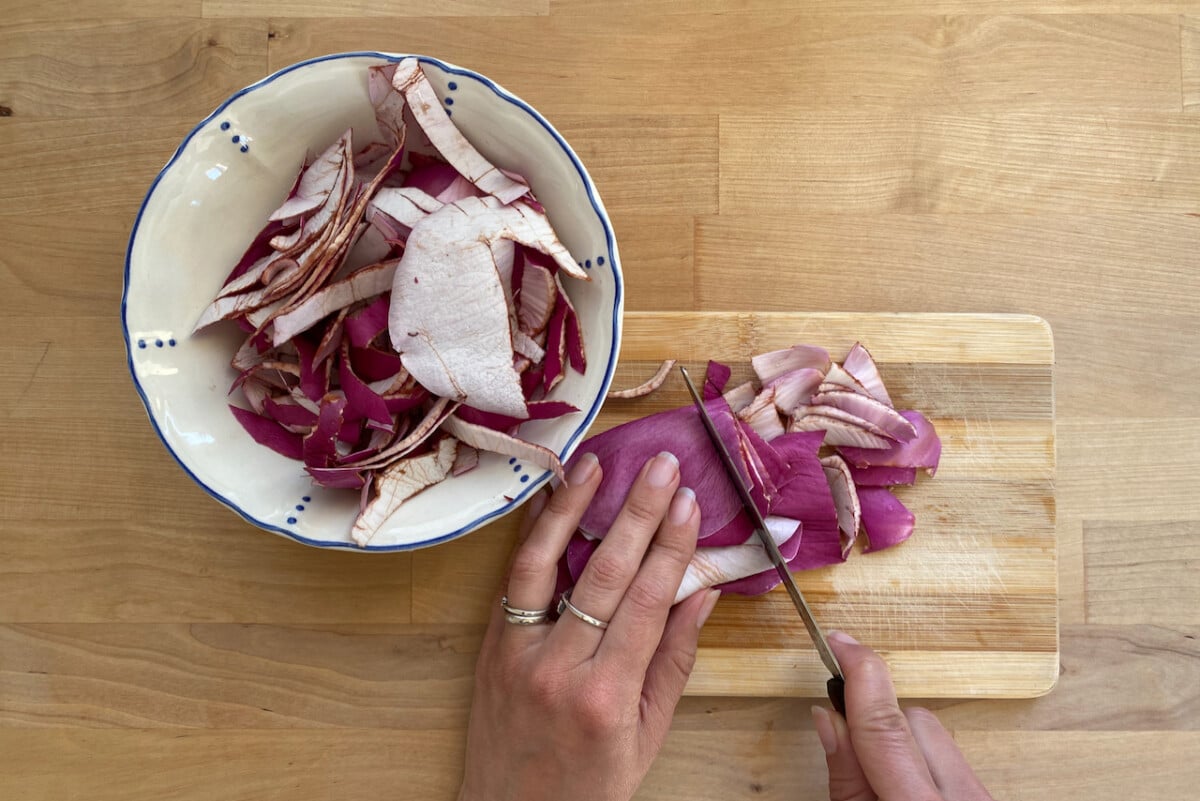 Hands slicing magnolia petals on cutting board