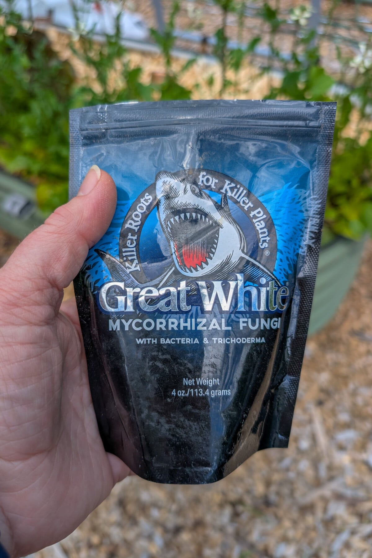 Hand holding a package of Great White mycorrhizal fungi