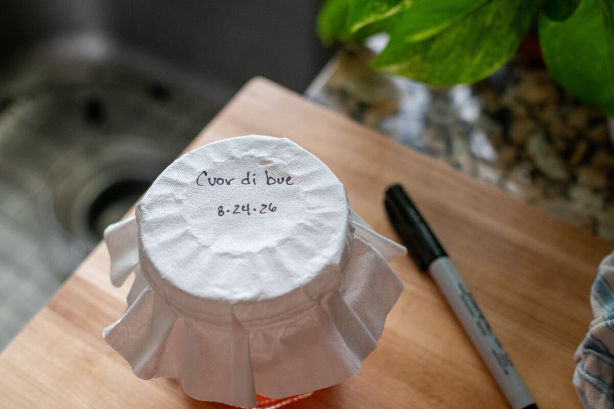 labeled jar of fermenting tomato seeds